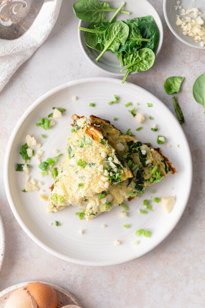 egg_frittata_on_plate_with_spinach_and_green_onions_elizabeth_rider